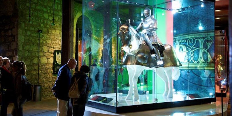 “Royal Armoury at Tower of London displaying medieval armor suits, including a mounted figure in full armor on horseback.”